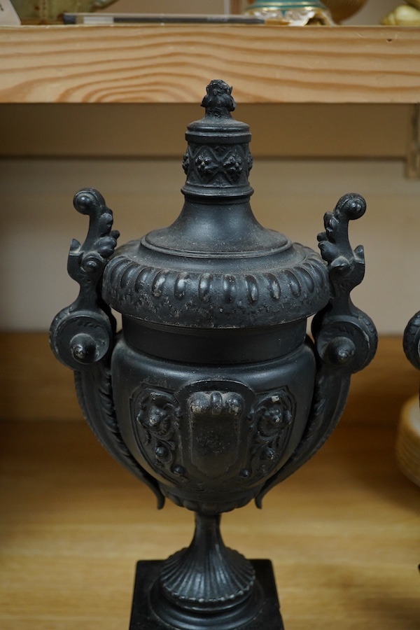 A pair of Victorian black metal and marble mantel clock garnitures, 45cm high. Condition - good